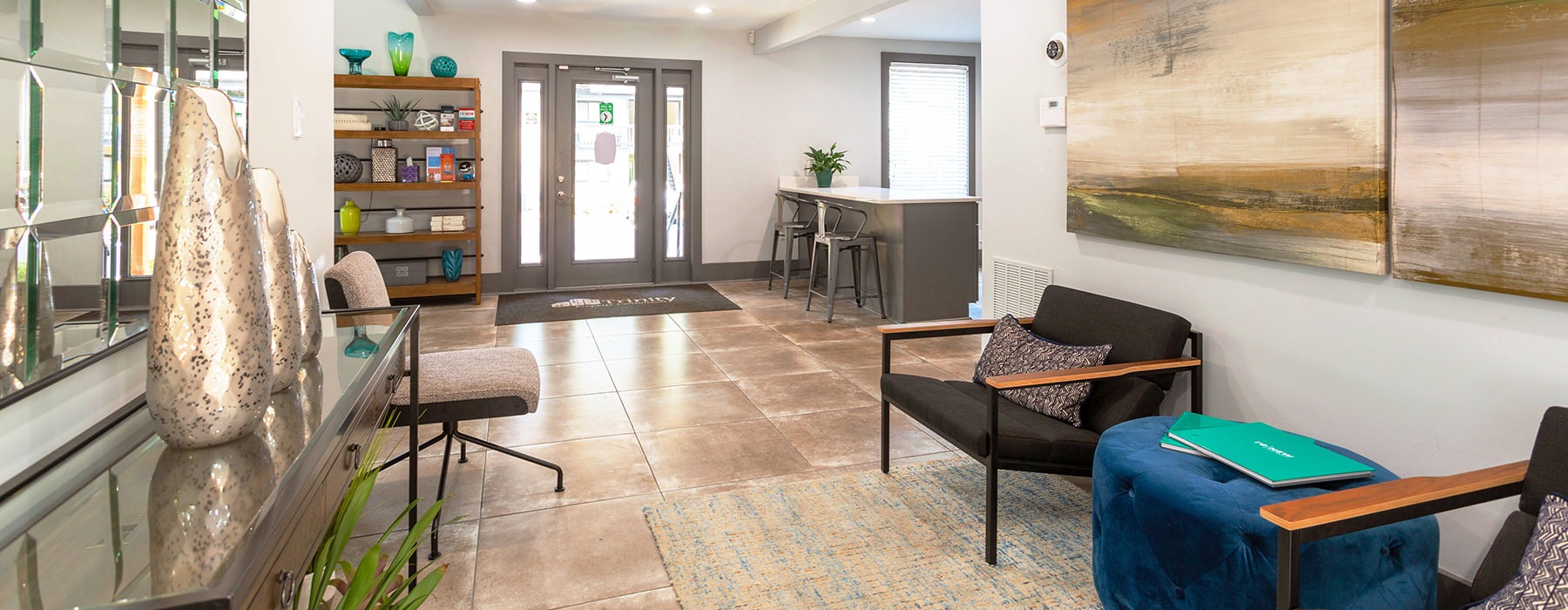 Spacious and well lit entrance to the leasing office with wood floors and plenty of seating	